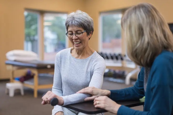 An occupational therapist consulting with an aged woman at a nursing center in Bossier City, LA