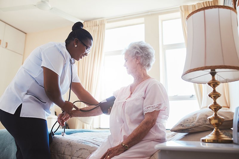 A Nurse checks an elderly Woman's blood pressure at a skilled nursing home in Bossier City, LA.