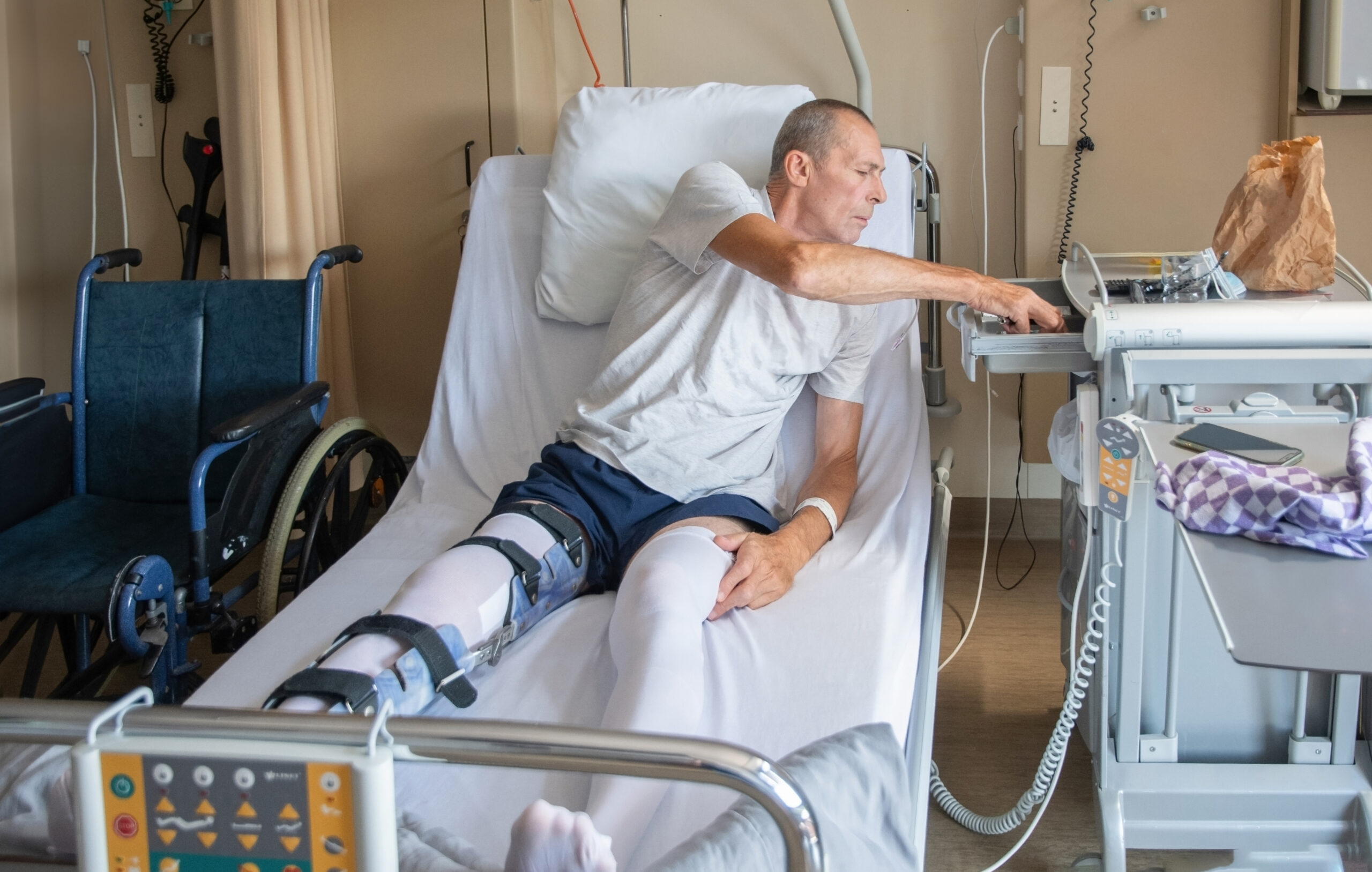 A man with a broken leg in an orthosis on a bed in a clinic after an accident and a fracture of the femur. He is receiving orthopedic surgery recovery services at a skilled nursing facility in Bossier City, LA.